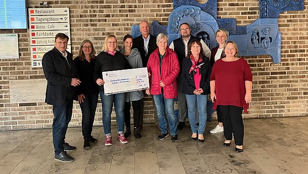 Representatives from Kroschu and the BBW with a large check at the donation handover